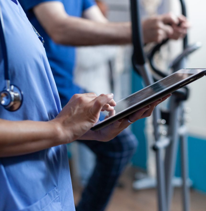 Close up of medical assistant touching tablet display Close up of medical assistant touching tablet display to help elder people with physical recovery. Nurse using gadget with touch screen for healthcare and physiotherapy for strength